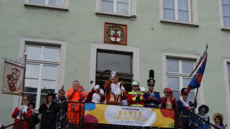 Rathausstürmung Karneval Koblenz Menschen in bunten Kostümen stehen auf einem Balkon und feiern eine Veranstaltung.